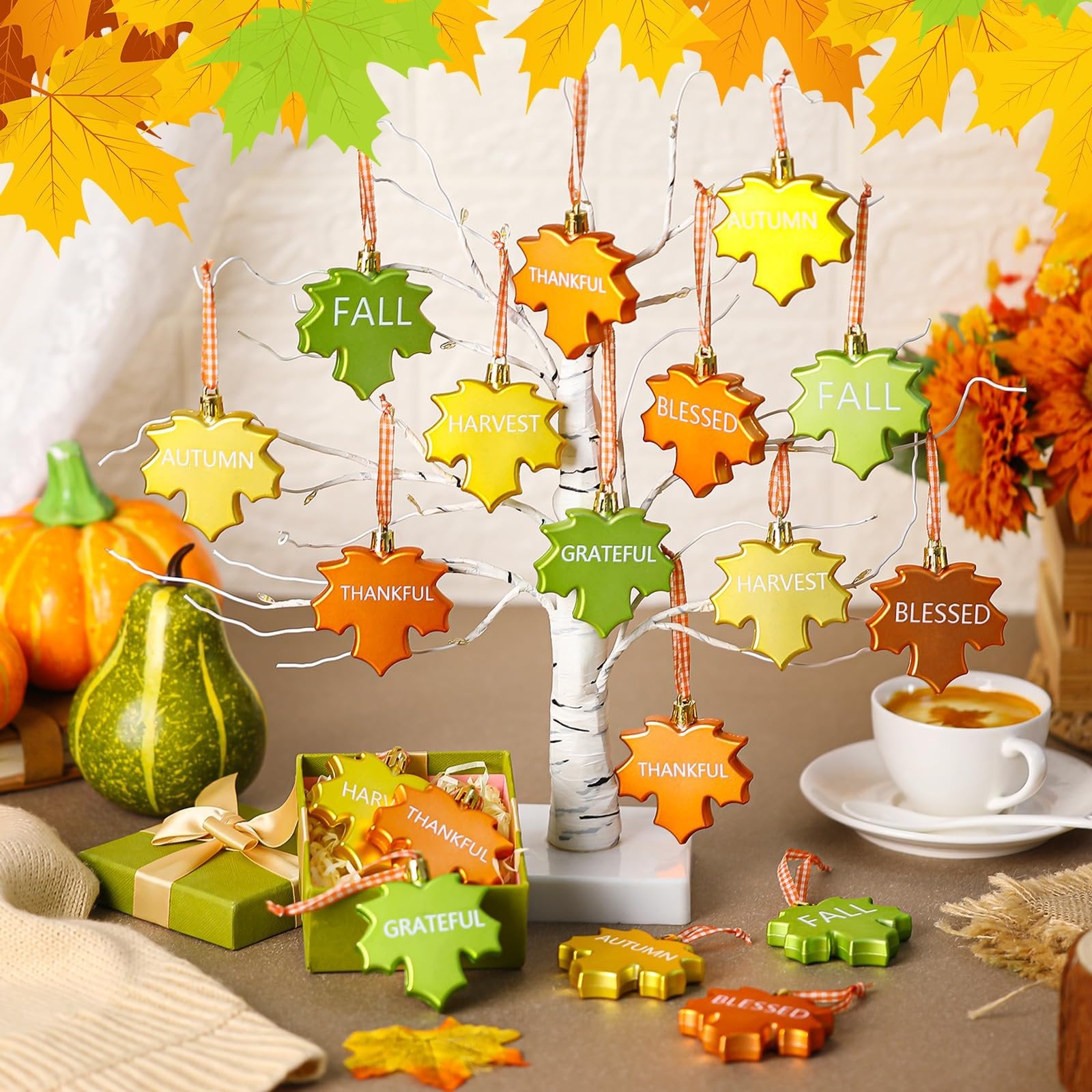 Thanksgiving leaf ornaments with words like Fall, Autumn, Harvest, Grateful, Thankful, Blessed displayed on a white tree and in a gift box.