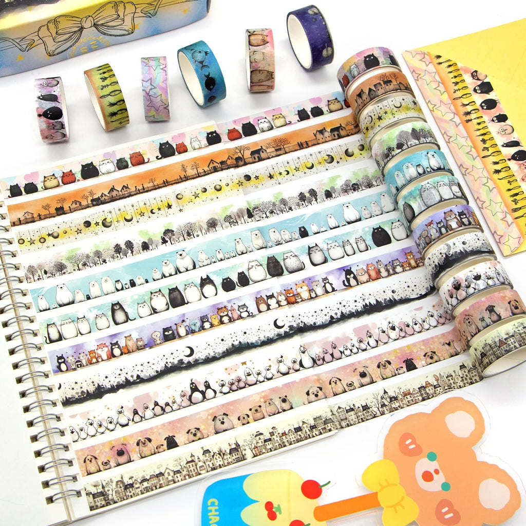 Collection of kawaii animal and landscape patterned washi tape rolls laid out on a spiral notebook.