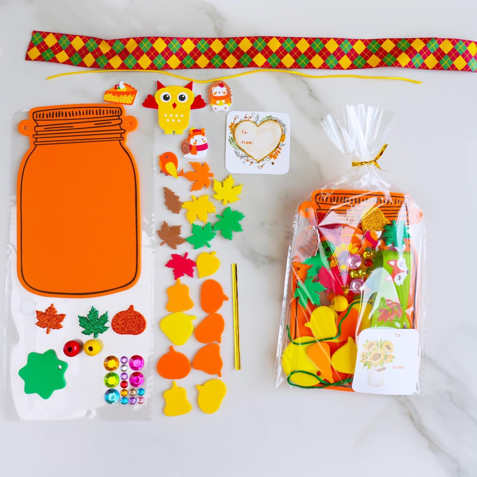 Fall mason jar ornament craft kit contents including foam shapes, stickers, beads, ribbon, and a treat bag.