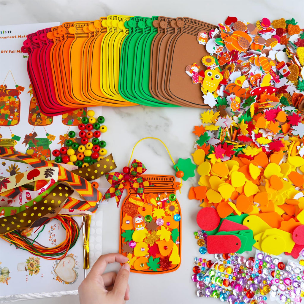 Fall mason jar ornament craft kit contents including foam bases, stickers, beads, ribbons, and gems.