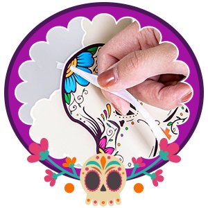 Hand attaching a hanging rope to a sugar skull craft kit decoration