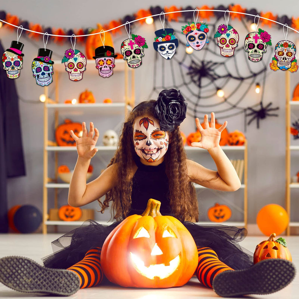 Girl with sugar skull face paint sits with a carved pumpkin, surrounded by Halloween decorations and a sugar skull garland.