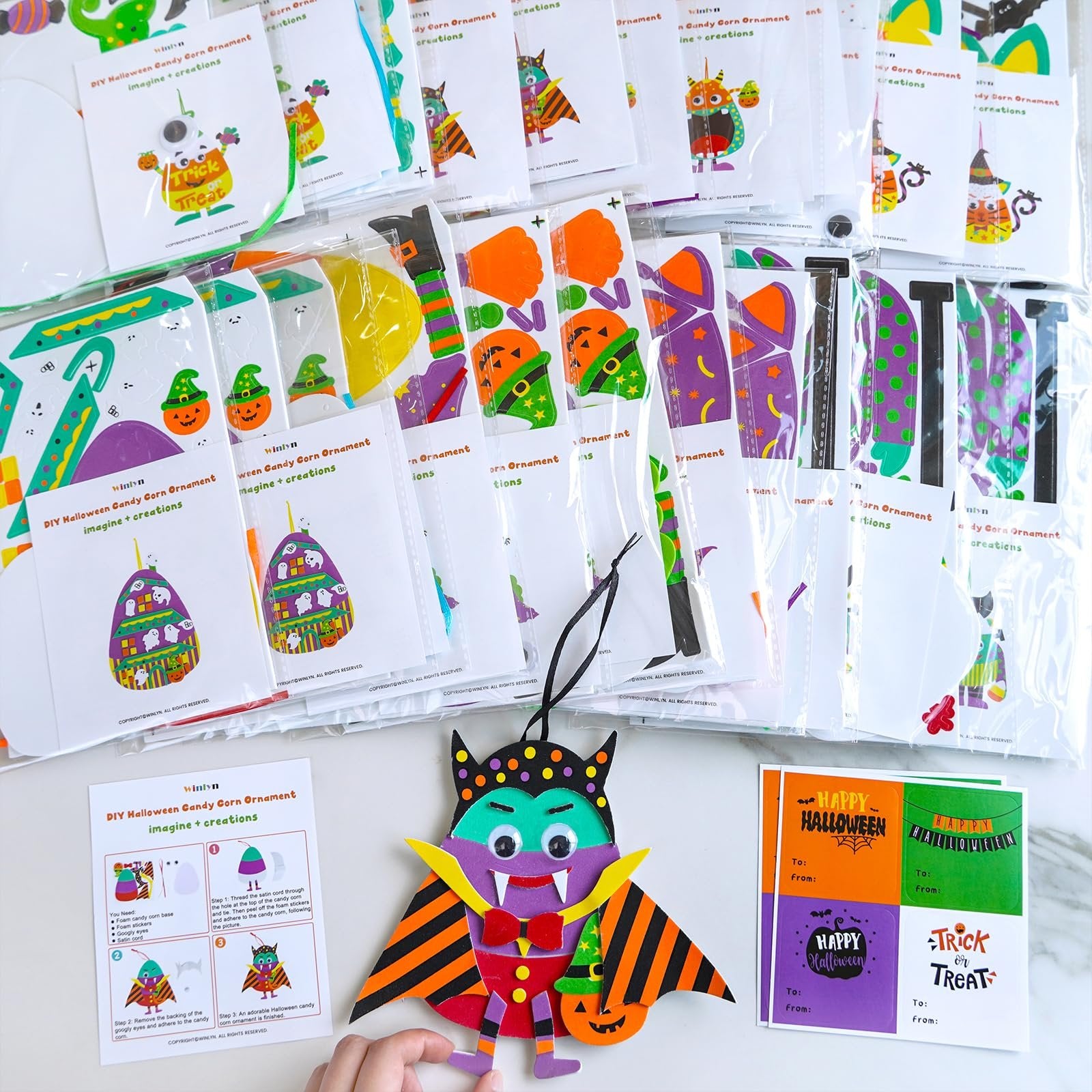 DIY Halloween foam ornament craft kits laid out with a finished vampire ornament and instructions.