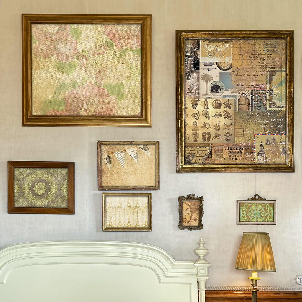 Collection of framed vintage-style artwork and scrapbook paper displayed on a wall above a bed.