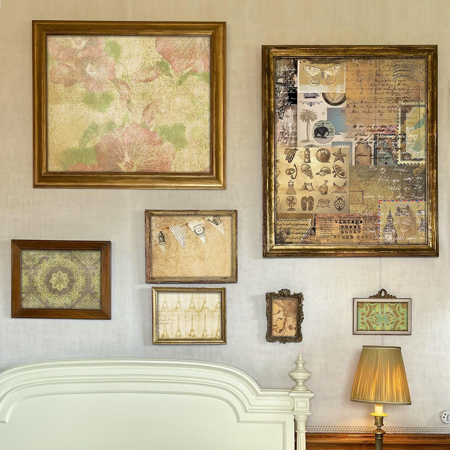Collection of framed vintage-style artwork and scrapbook paper displayed on a wall above a bed.