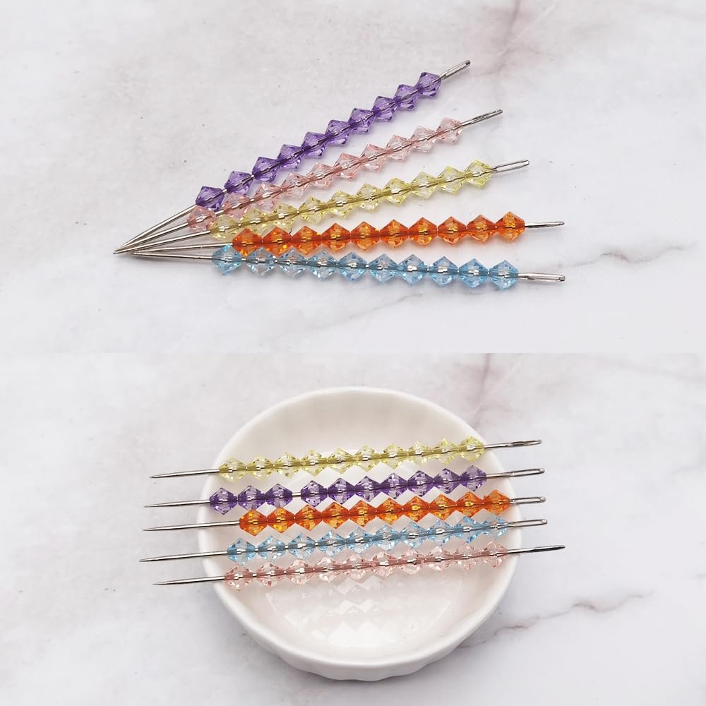 Assortment of faceted acrylic beads on metal needles, displayed on a white marble surface and in a white dish.