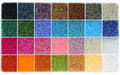 Top-down view of a clear plastic organizer filled with 28 compartments of colorful 2mm glass seed beads for jewelry making.