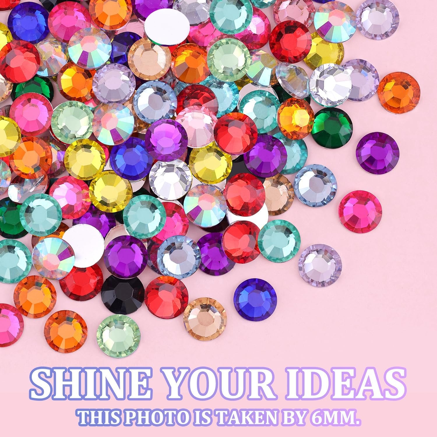 Assortment of colorful 3mm resin rhinestones scattered on a pink background.