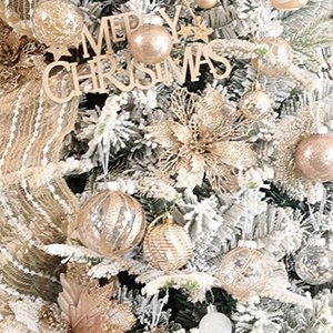 Assortment of clear plastic Christmas ball ornaments with glitter fill and decorative elements on a flocked tree.