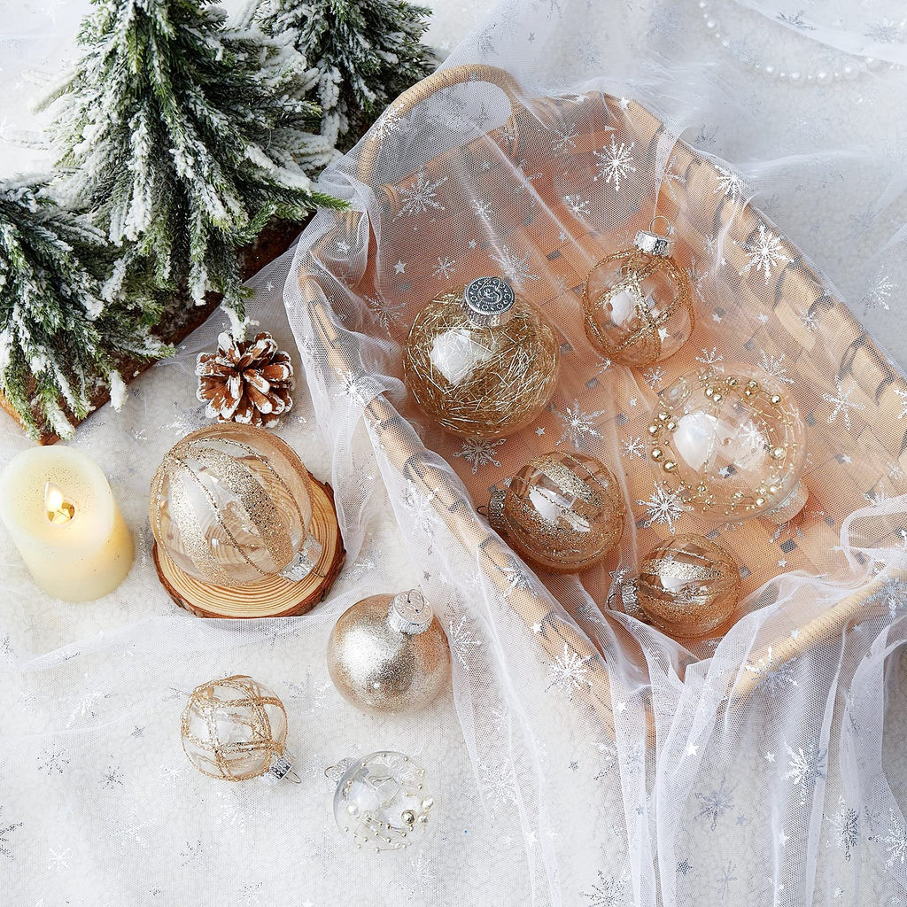 Clear plastic Christmas ball ornaments with glitter fill and gold string accents, arranged with festive decor.