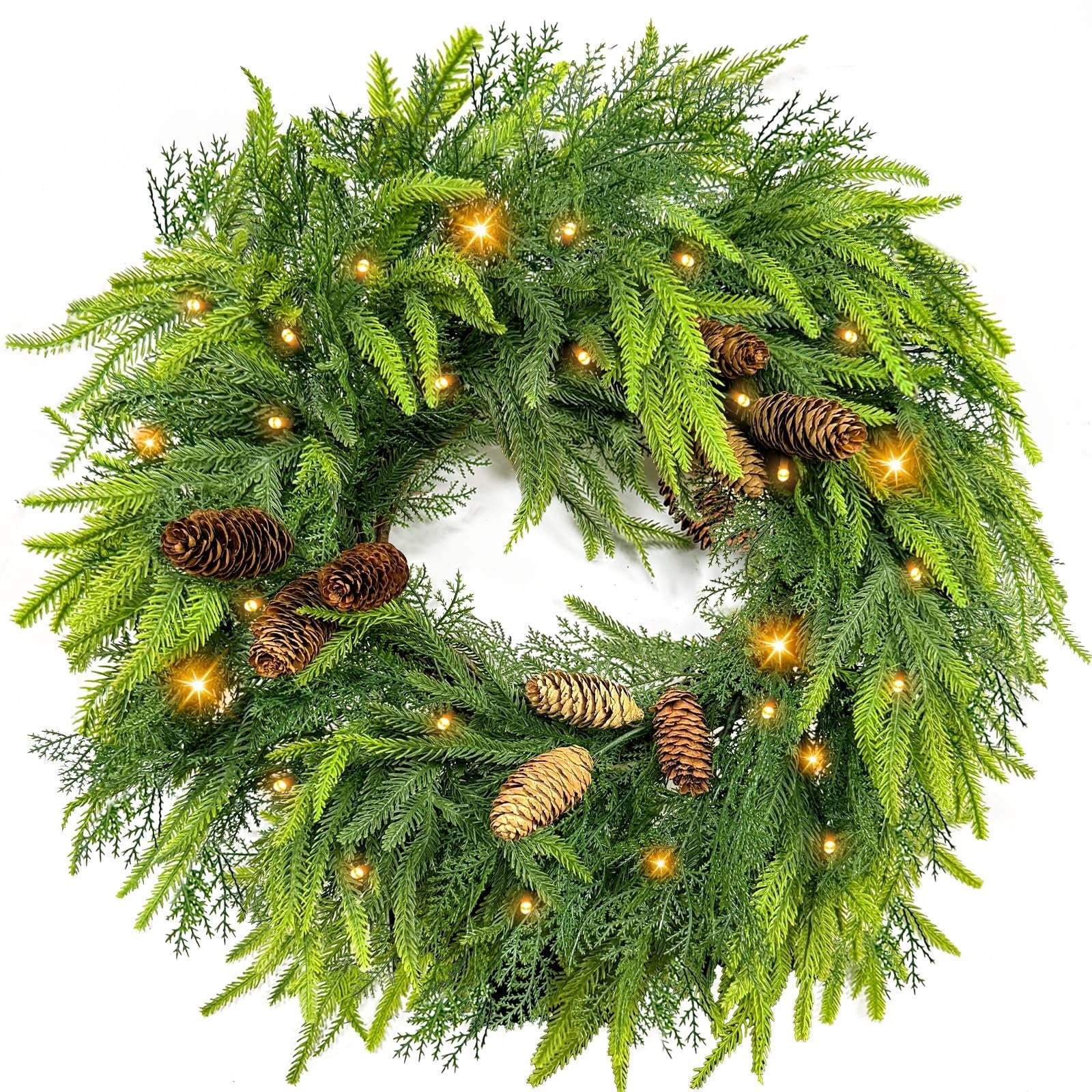 Green artificial wreath with pine cones and warm LED lights, displayed against a white background.