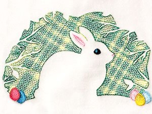 White rabbit with green leafy arch and Easter eggs, embroidered design on white fabric
