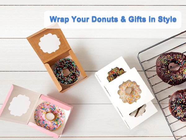 Three open treat boxes with donuts inside, and two donuts on a cooling rack.
