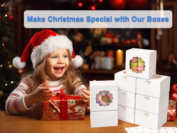 Christmas scene with a child opening a gift next to a stack of white bakery boxes filled with macarons and donuts