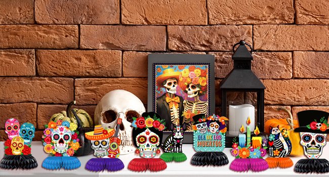 Day of the Dead sugar skull cutouts and decorations arranged on a shelf with a skull, pumpkin, and lantern.