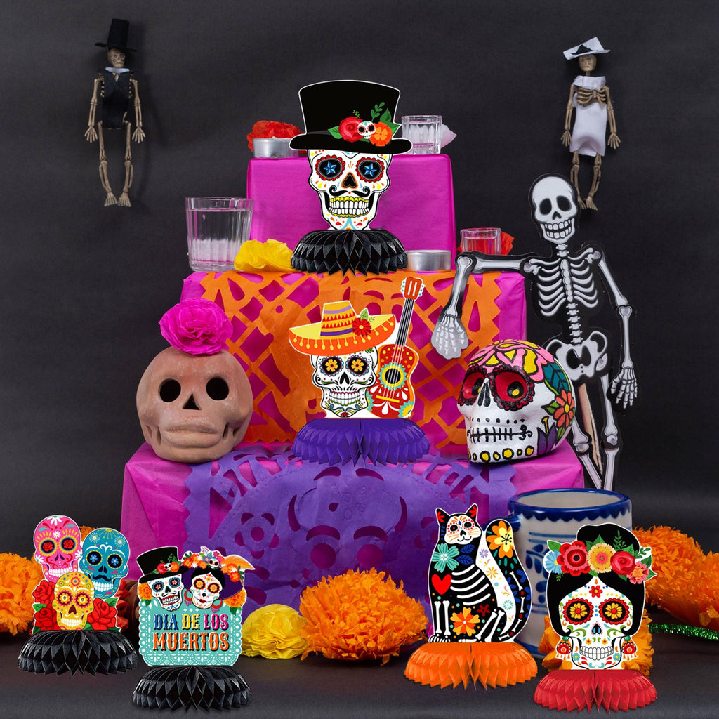 Day of the Dead sugar skull cutouts and skeletons arranged as a festive altar display with marigold flowers and candles.