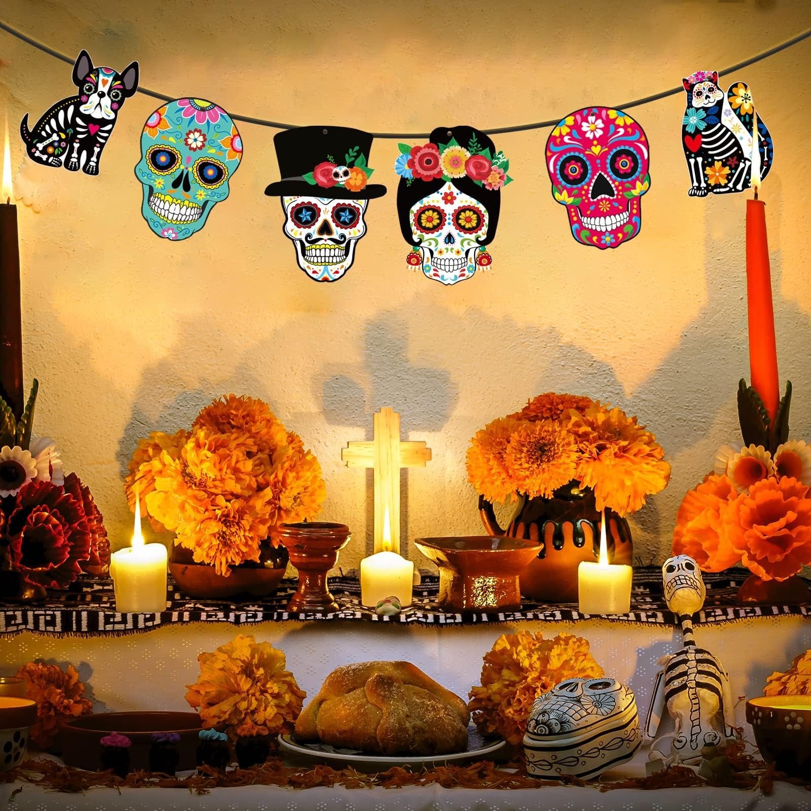 Day of the Dead altar with sugar skull cutouts, marigolds, candles, and bread.