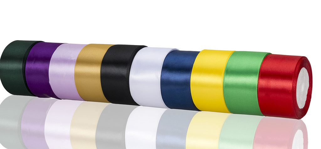 Multiple rolls of satin ribbon in various colors including green, purple, gold, black, white, blue, yellow, and red, displayed horizontally with reflections.