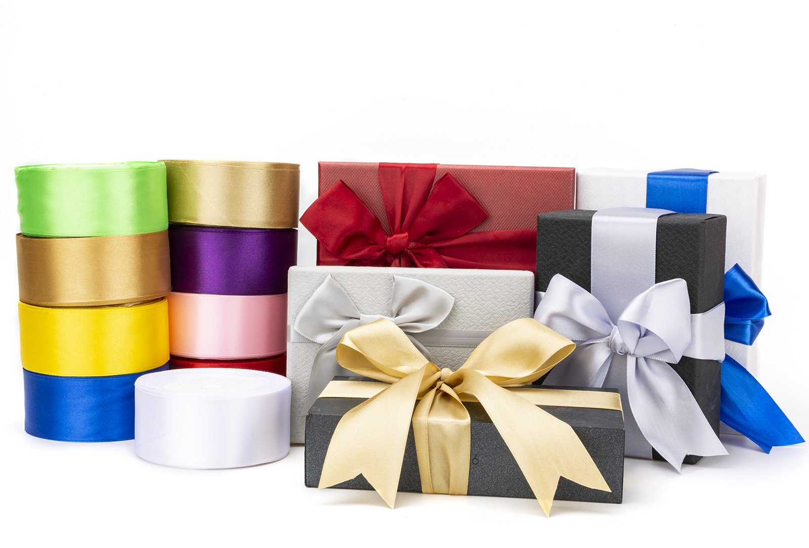 Assortment of colorful satin ribbon rolls and gift boxes with bows on a white background.