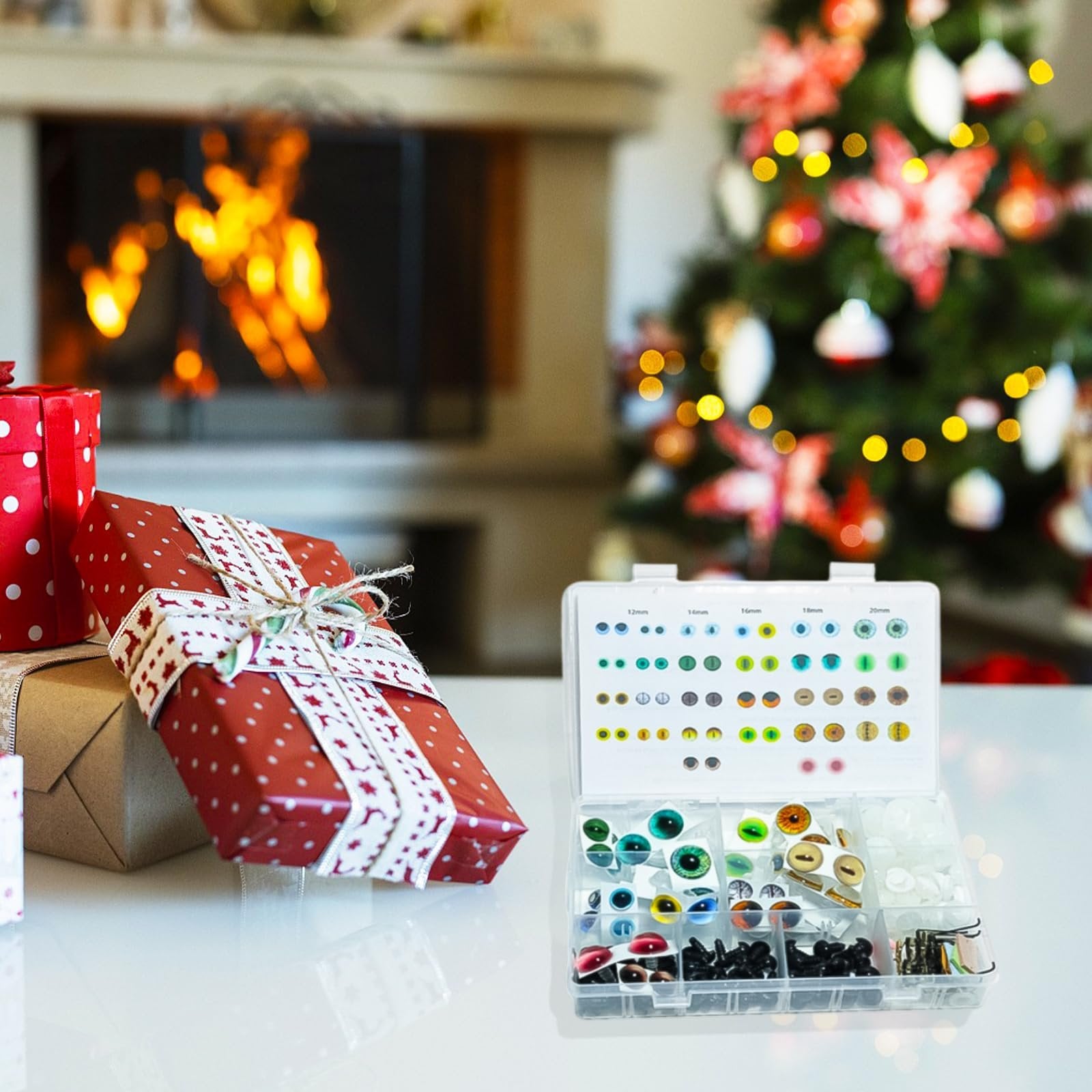 Amigurumi safety eyes kit with various sizes and designs in a clear plastic organizer, with Christmas gifts and a decorated tree in the background.