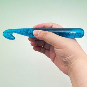 Hand holding a large blue glitter crochet hook with 20MM size marking on the handle