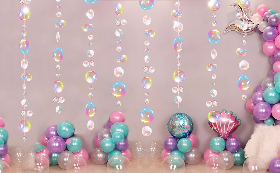Iridescent bubble garlands hanging in front of a wall with balloons and a mermaid-themed foil balloon.