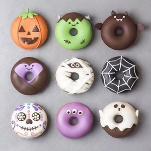 Nine Halloween-themed decorated donuts arranged in a 3x3 grid on a gray surface.