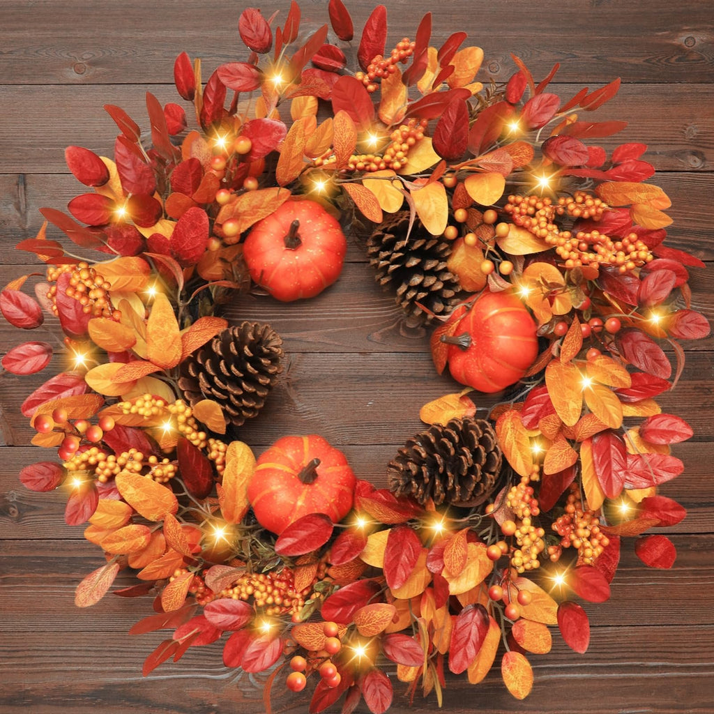 Foldable fall wreath with pumpkins, pinecones, berries, and LED lights on a wooden background.