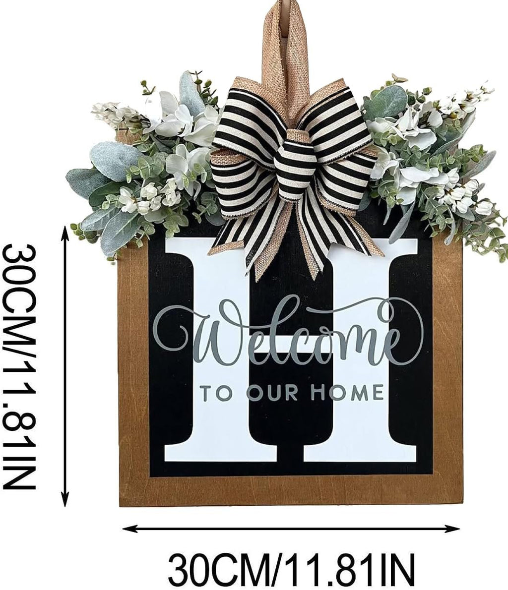 Wooden welcome sign with eucalyptus garland, bow, and large monogram letter 'H' for front door decor