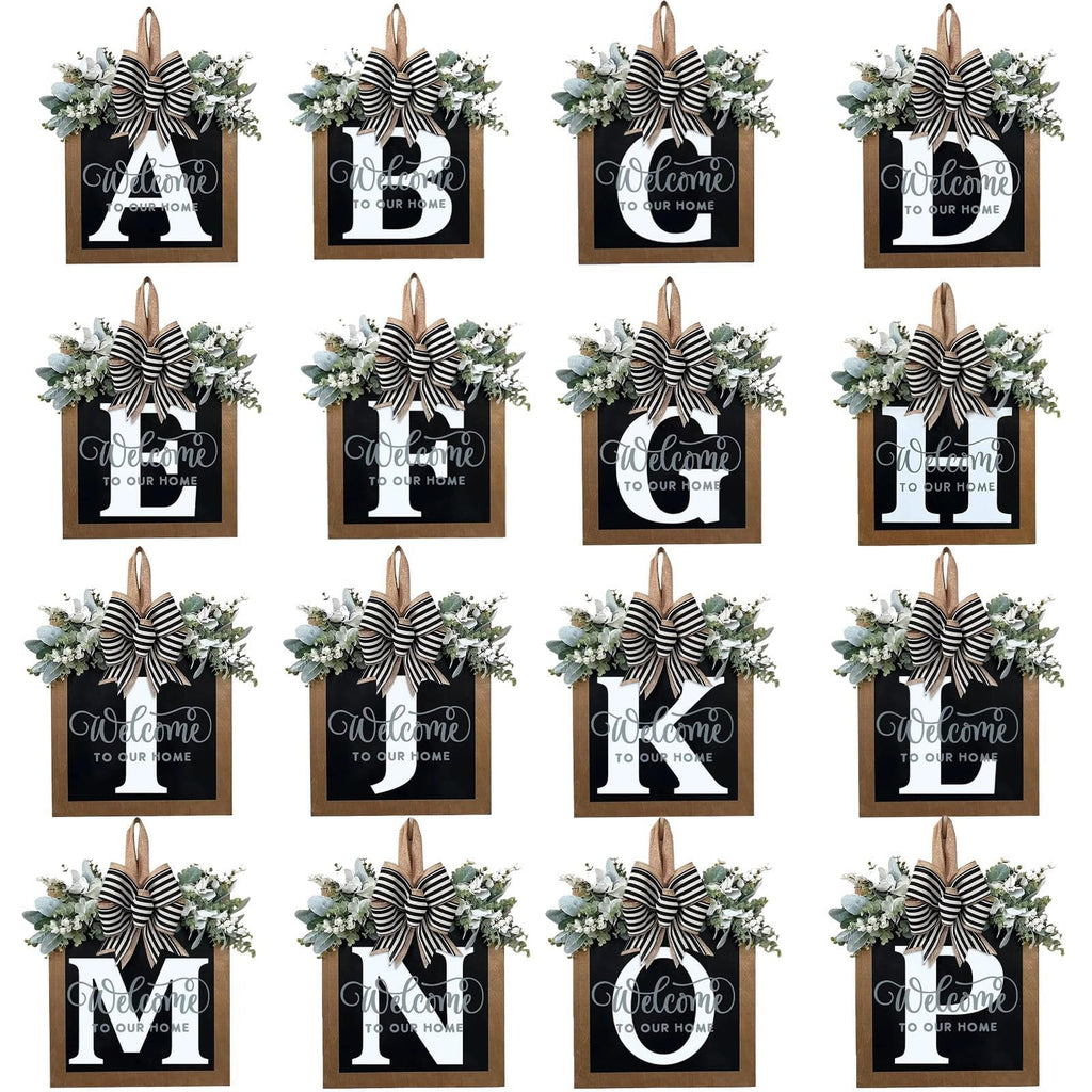 Grid of 16 decorative wooden door wreaths, each featuring a letter from A to P, eucalyptus garland, and a striped bow.