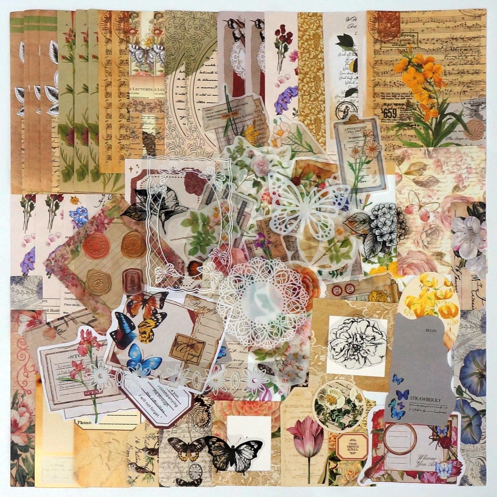 Flat lay of vintage floral and butterfly scrapbooking paper, stickers, and embellishments.