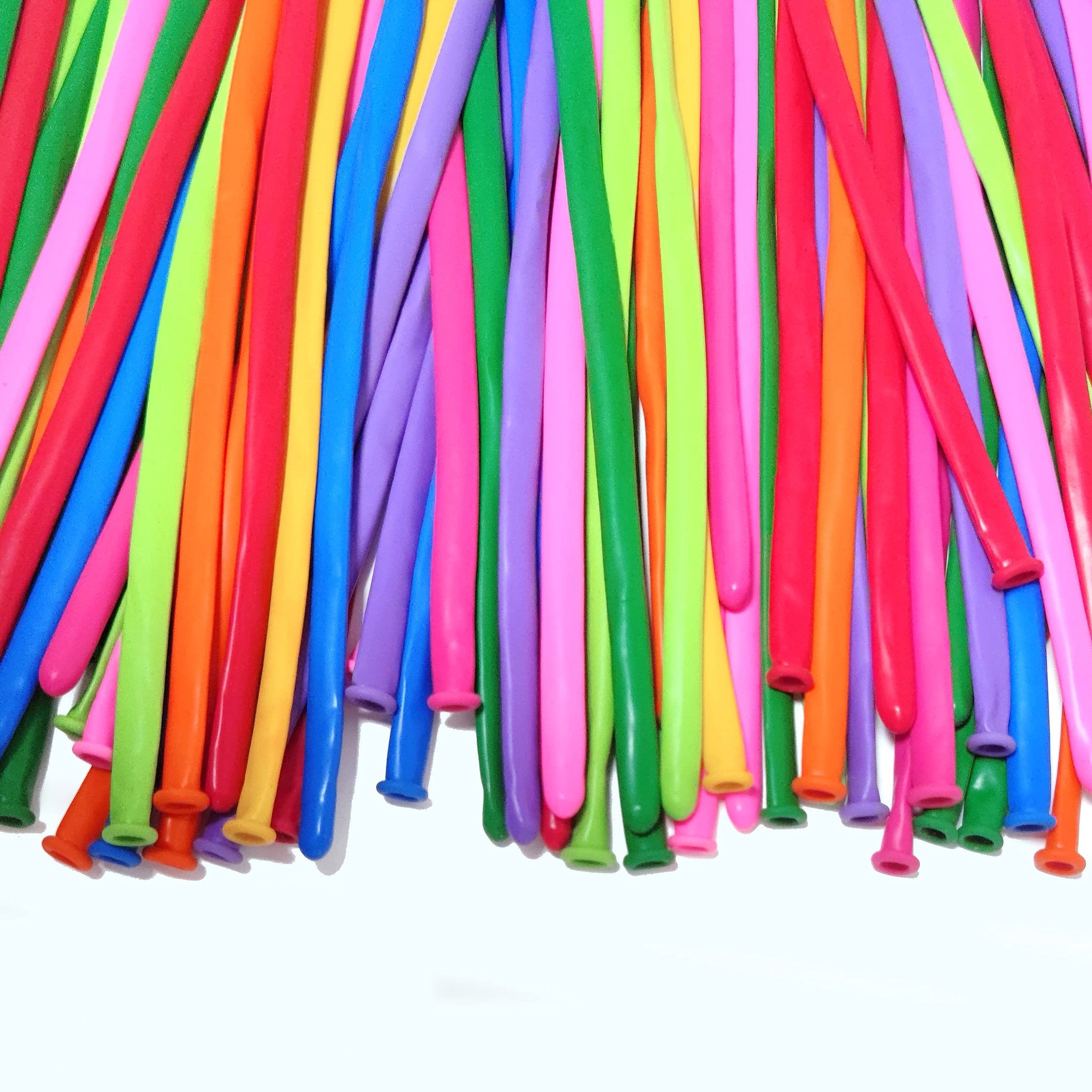 Assorted color twisting balloons for balloon animals, laid out in a dense pile against a white background.