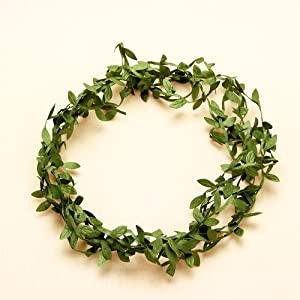 Artificial olive green leaf vine ribbon formed into a wreath on a light background