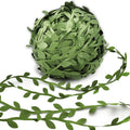 Roll of olive green artificial leaf vine ribbon with vine strands laid out in front on a white background