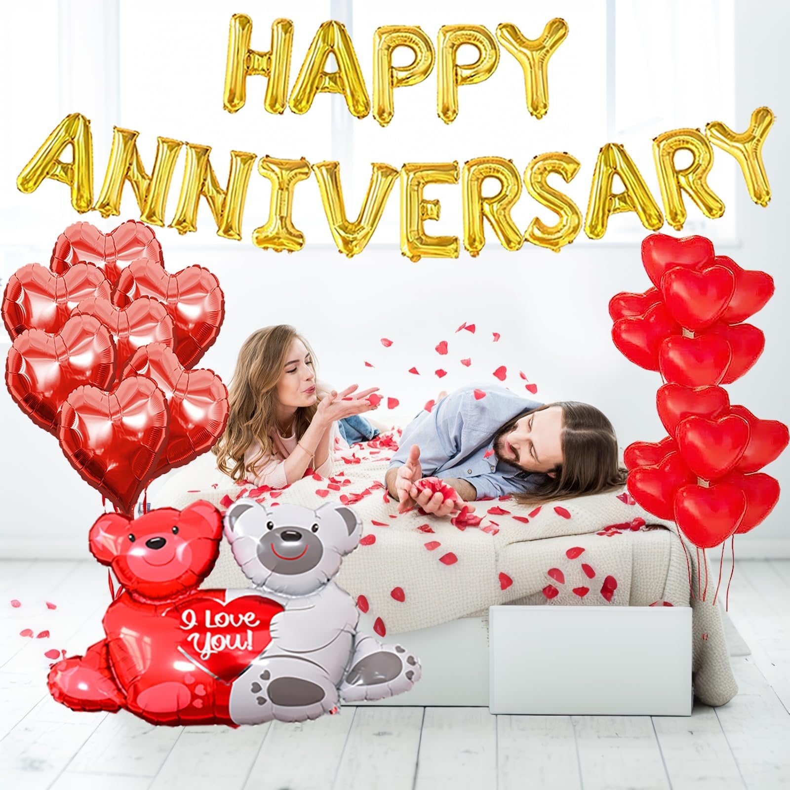 Couple in bed surrounded by anniversary balloons and rose petals, one blowing kisses