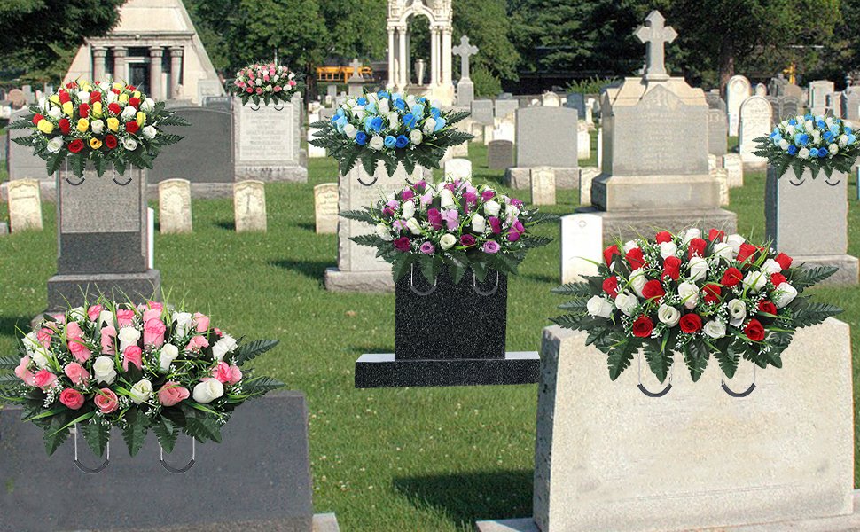 Assortment of artificial flower arrangements in various colors placed on headstones in a cemetery setting.