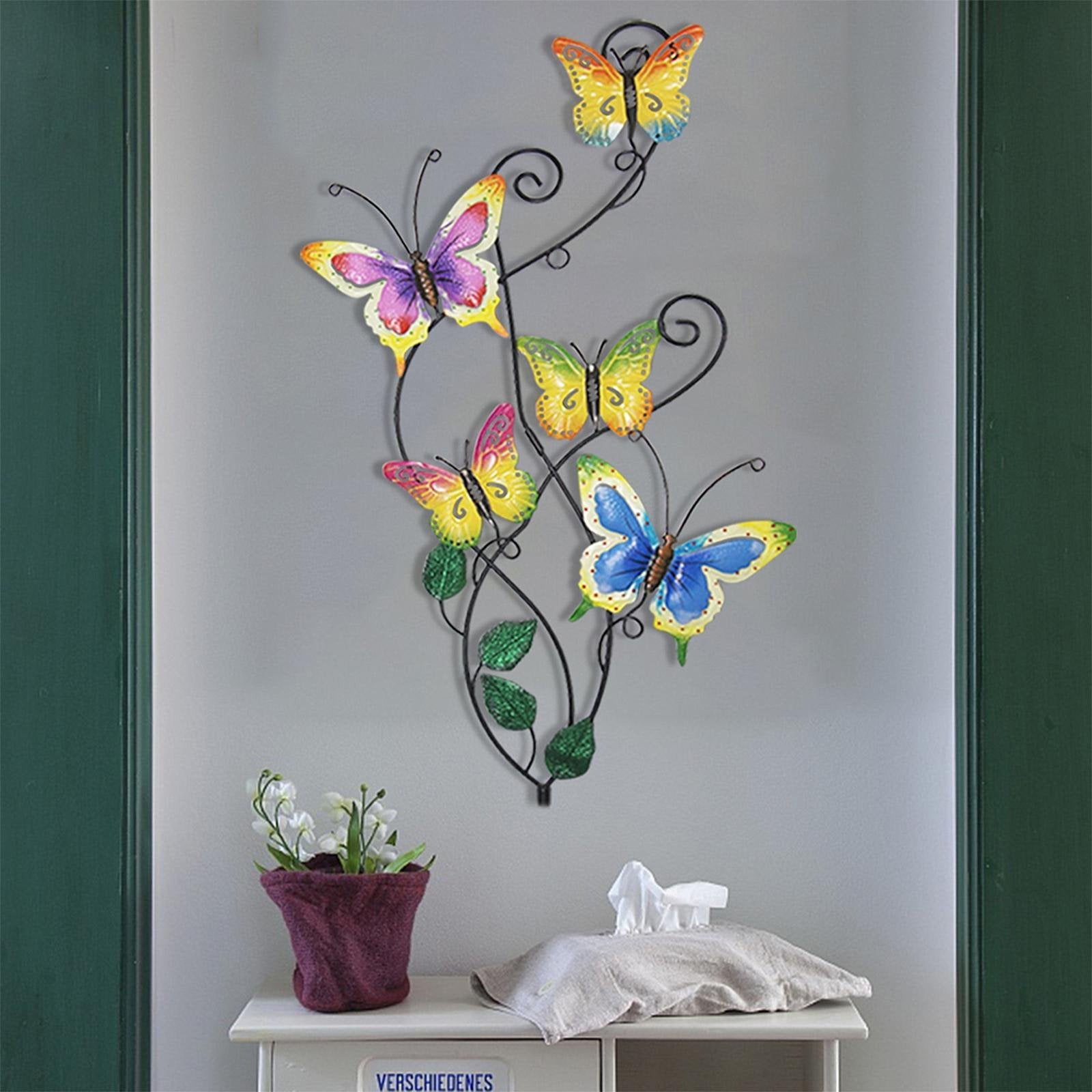 Metal butterfly garden stake and wall art decor with five colorful butterflies on a vine, displayed indoors.