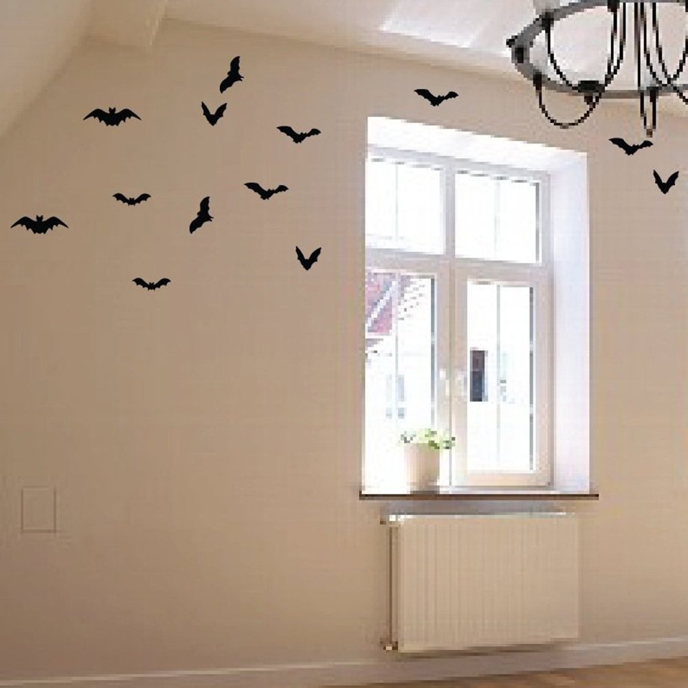 Black PVC bat wall decals arranged on a cream wall near a window and radiator.