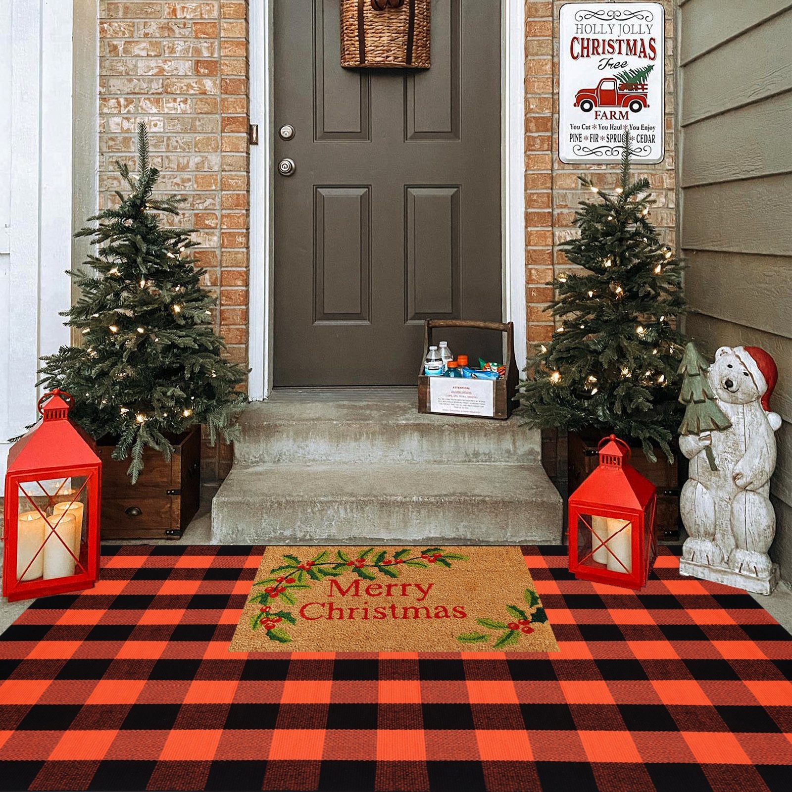 Orange and black buffalo plaid rug layered with a Merry Christmas doormat on a porch with decorated trees and lanterns.