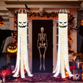 Two white Halloween ghost windsocks with jack-o-lantern faces and string lights, hanging on a porch with spooky decorations.