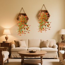 Two hexagonal wall shelves with faux silk daisy hanging flowers and eucalyptus leaves, displayed above a sofa.