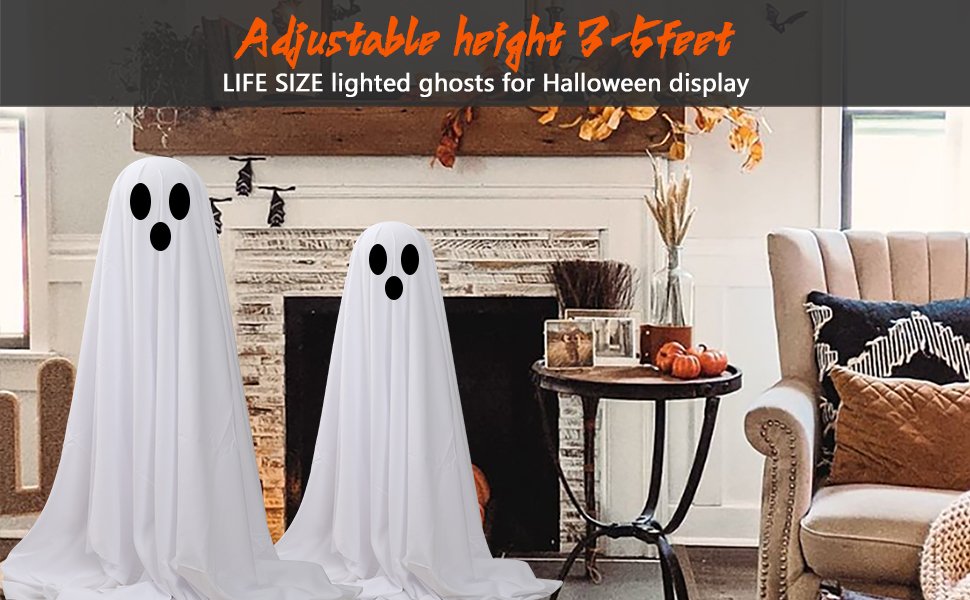 Two large white cloth ghosts with black eyes displayed indoors near a fireplace and armchair.