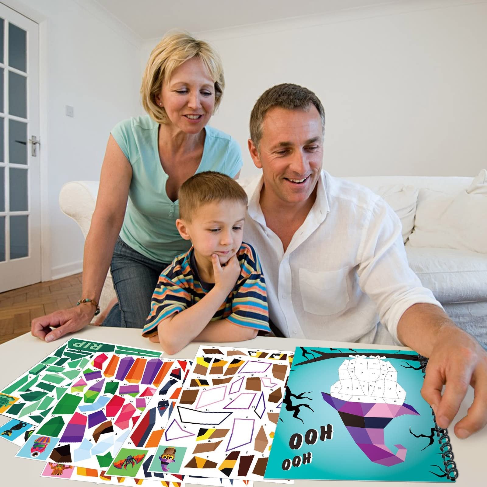 Family looking at sticker paint books with Halloween designs on a table