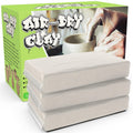 Three blocks of white air-dry clay stacked, with a box showing hands working clay in the background.