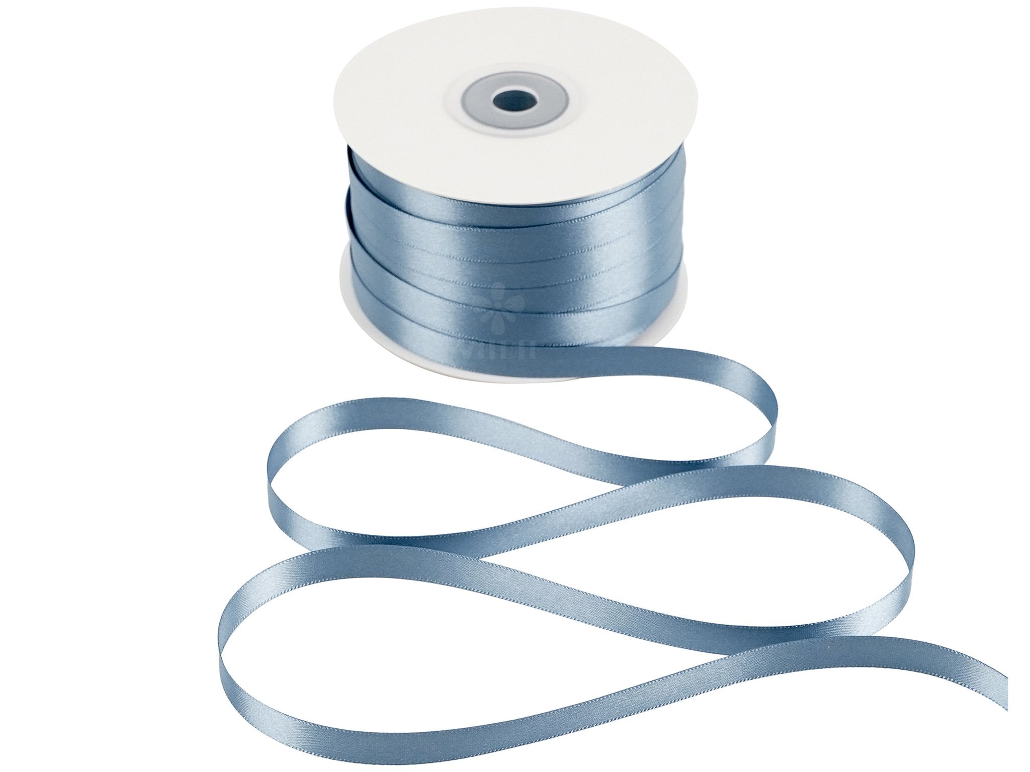 Spool of dusty blue double sided satin ribbon with ribbon unspooling in a wavy pattern on a white background.