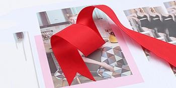 Red satin ribbon tied into a bow, laid over printed images of people and furniture.