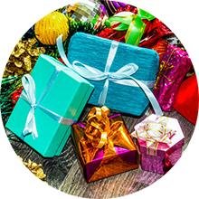Assortment of colorful gift boxes tied with ribbons on a wooden surface, surrounded by festive decorations.