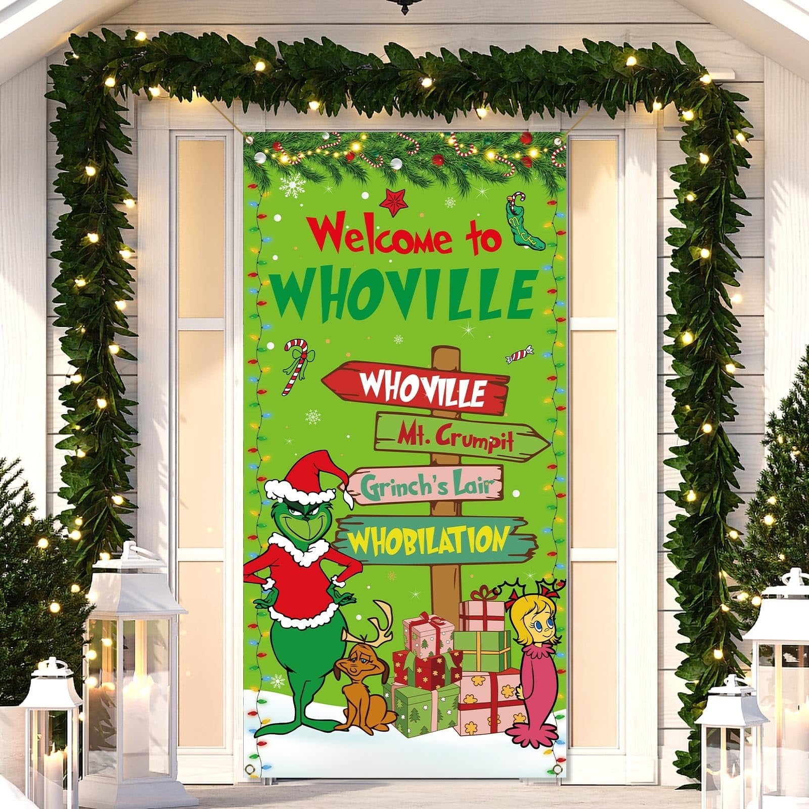 Christmas banner with Grinch characters and Whoville signs hanging on a door, decorated with garlands.