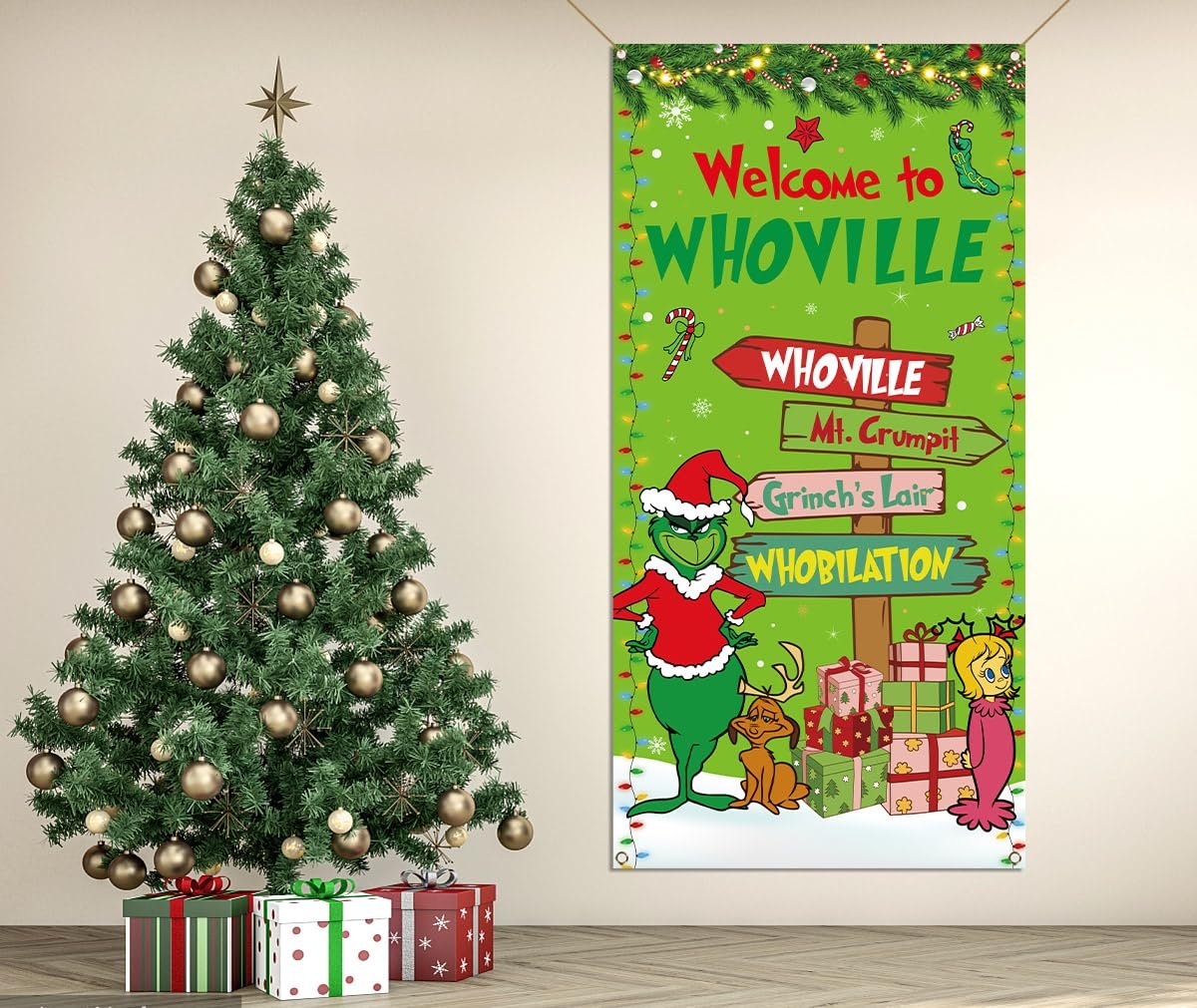 Christmas banner with Grinch characters and Whoville signs next to a decorated Christmas tree