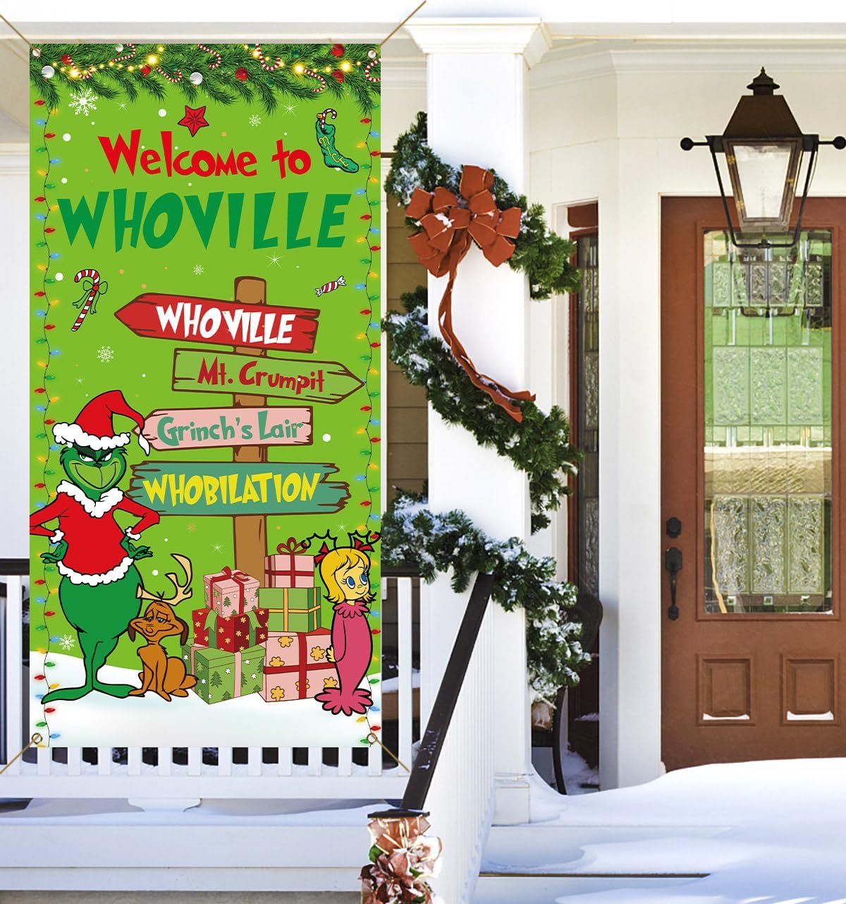 Christmas banner with Grinch characters and Whoville signs, displayed on a snowy porch.